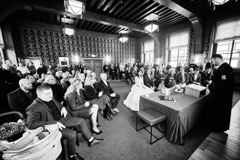 De volle trouwzaal met het bruidspaar vooraan
