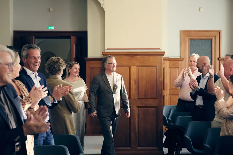 Jiska en Gerrit lopen de trouwkamer binnen, de gasten klappen