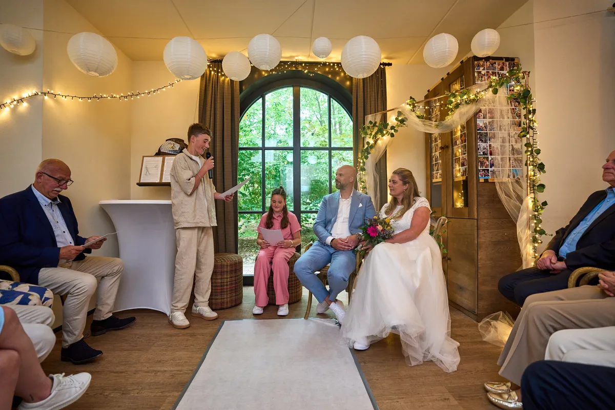 De woonkamer met lampionnen en lichtjes, het bruidspaar zit voor het raam