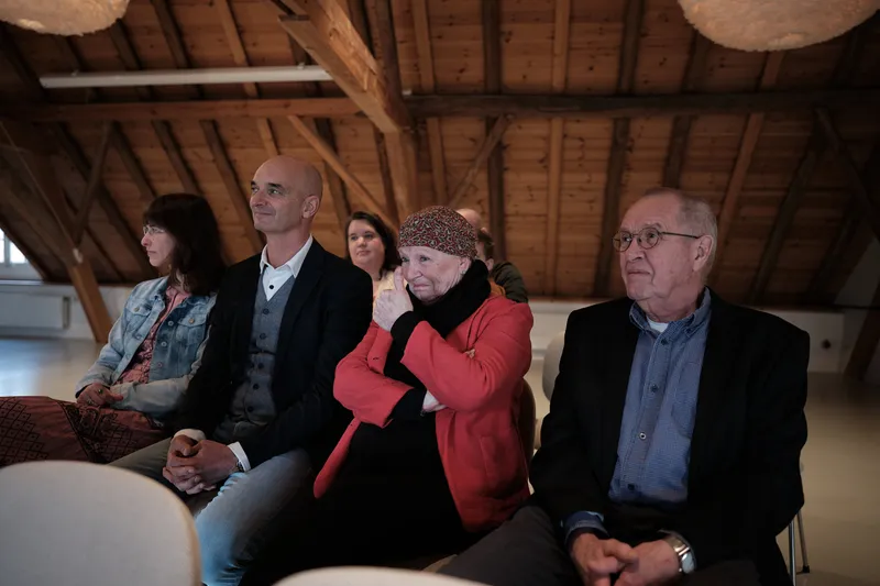 De gasten op de eerste rij lachen tijdens de ceremonie