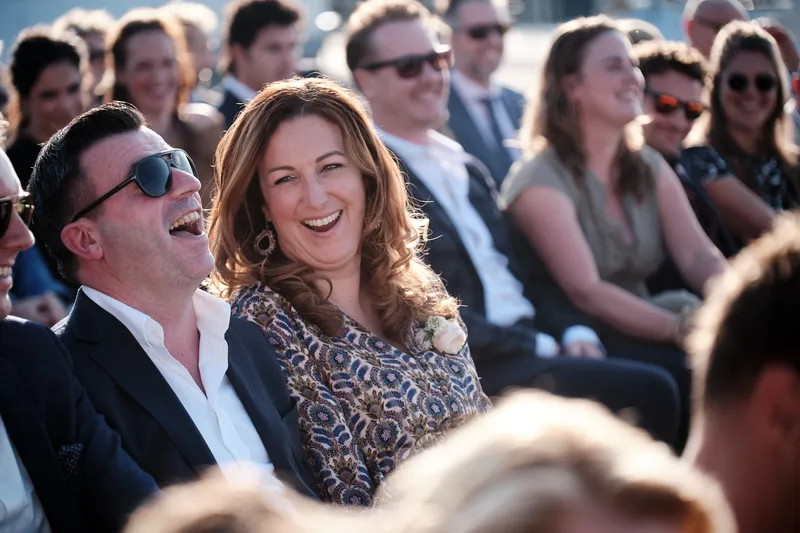 Gasten lachen tijdens de ceremonie