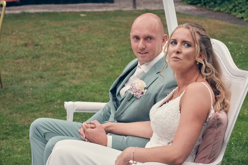 Kim en Dennis zitten op witte stoelen in de tuin