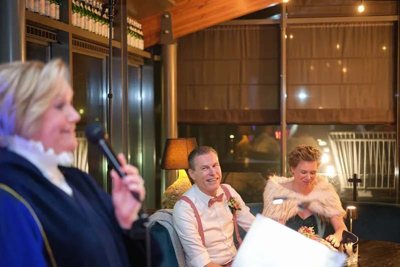 De trouwambtenaar lacht naar het bruidspaar