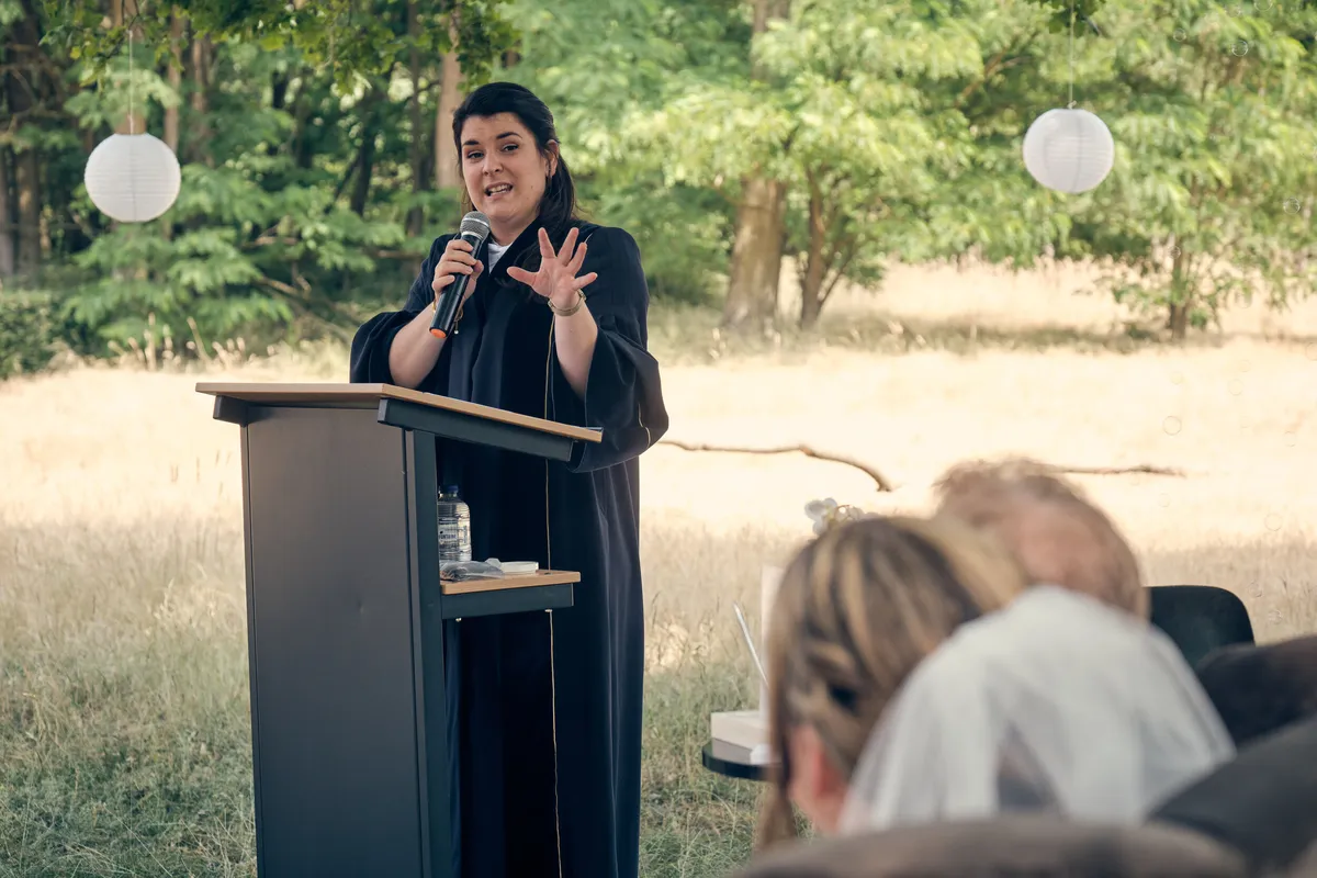 De BABS spreekt achter de houten lessenaar tijdens de ceremonie
