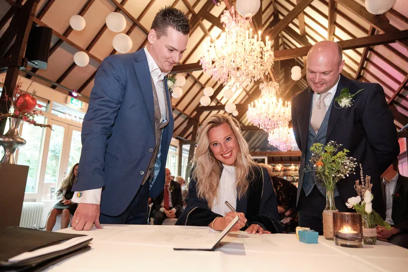 Een getuige tekent aan de tafel