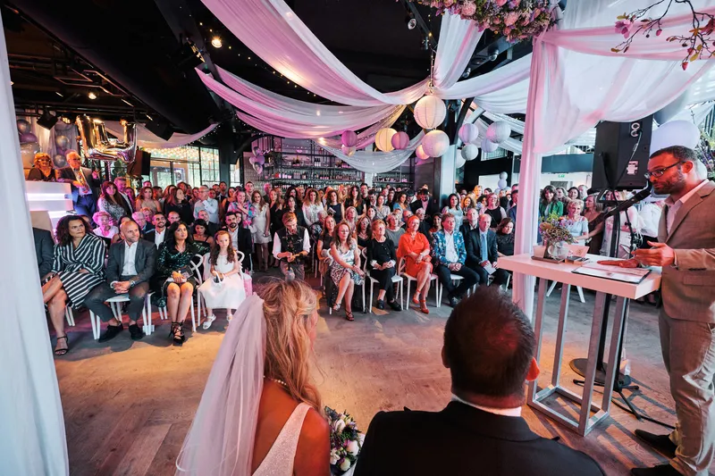 De zaal met witte doeken en roze licht