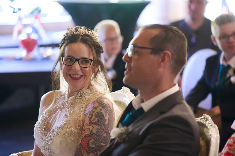 Karon en Pieter lachen naast elkaar tijdens de ceremonie
