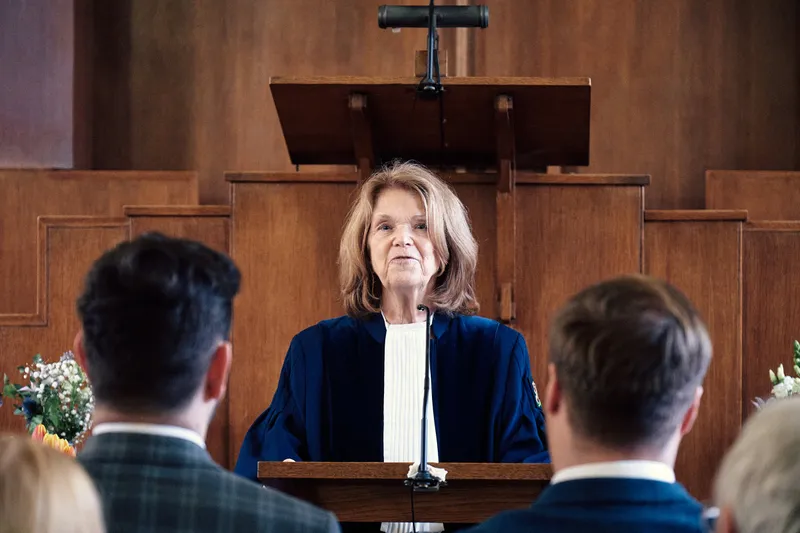 De trouwambtenaar spreekt Joey en Twan toe vanachter de lessenaar