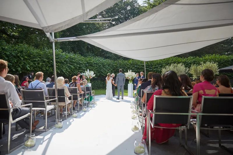 De ceremonie onder het witte doek, met de gasten aan weerszijden