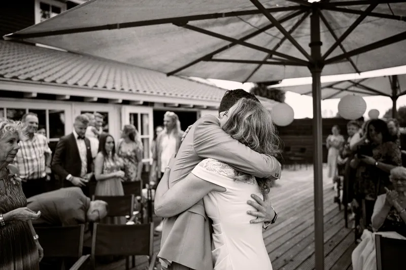 Een omhelzing bij aankomst op het terras, tussen de gasten