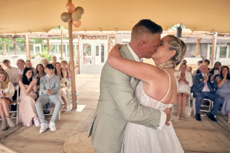 Marco en Tamara kussen, de gasten in de tent erachter