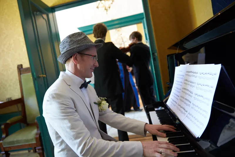 Een pianist in witte jas aan de vleugel