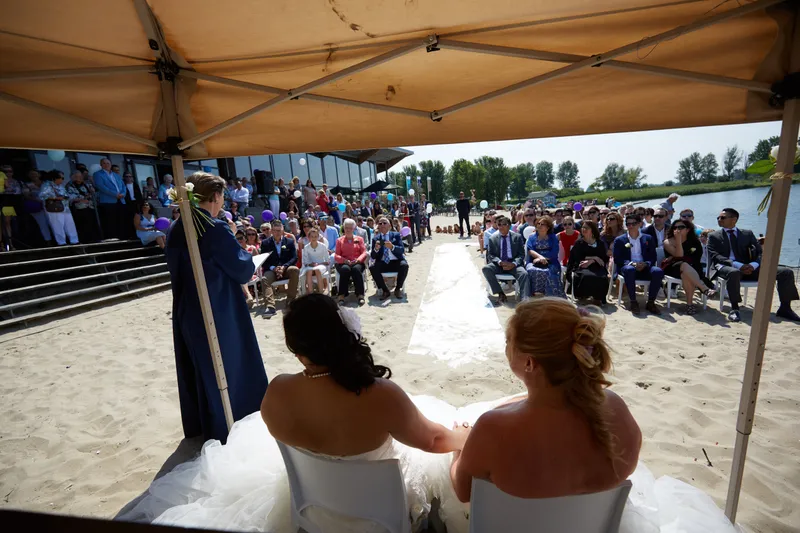 Prunella en Cora onder de parasol, met de gasten op de tribune