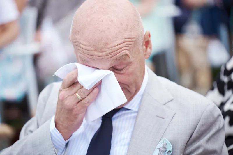 Een gast veegt een traan weg tijdens de ceremonie