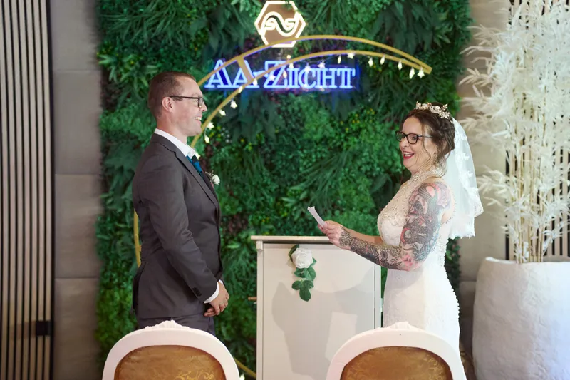 Karon en Pieter voor de groene wand met het logo van AA-Zicht