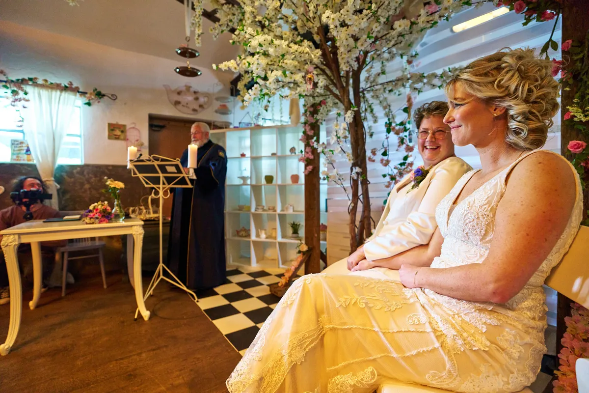Froukje en Mireille zitten onder de bloesemboom, de BABS staat achter de lessenaar