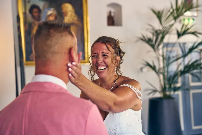 Diliana legt lachend haar hand op de wang van Olav