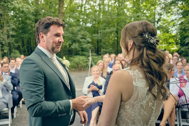 Fabian schuift de ring om de vinger van Renée, de gasten kijken toe