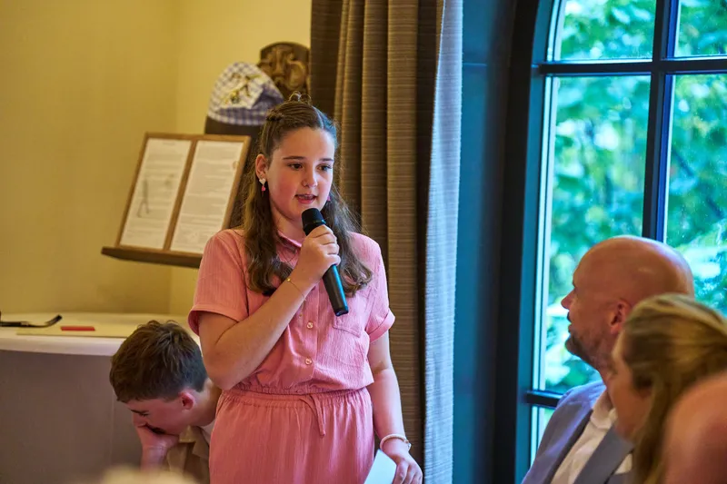 Hun dochter spreekt met de microfoon in haar hand