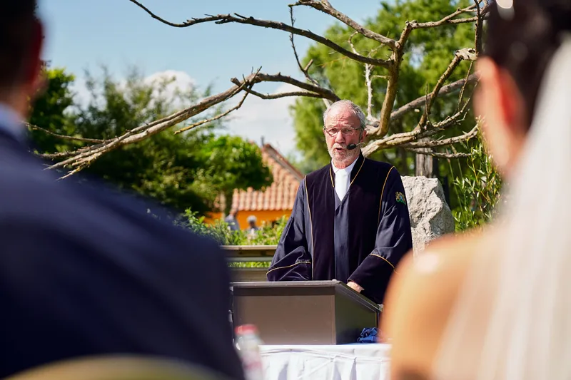 De trouwambtenaar spreekt onder de bomen