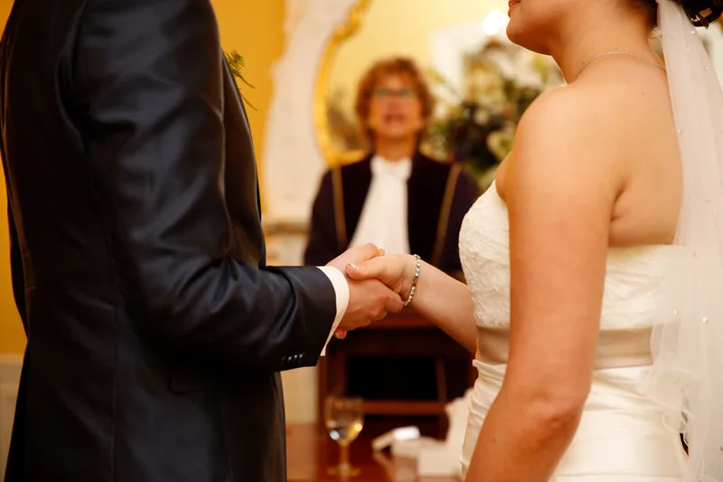 Tessa en Wessel geven elkaar de hand bij de trouwambtenaar