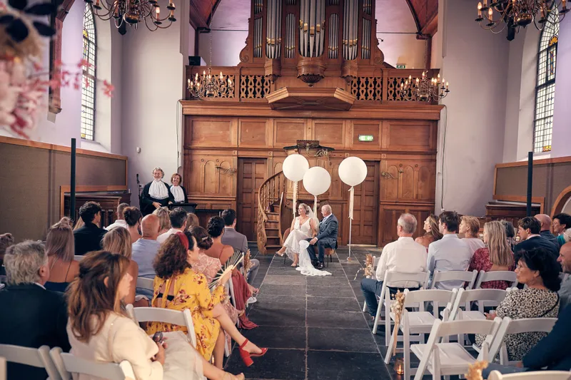 De kerk vol gasten, met het orgel achterin