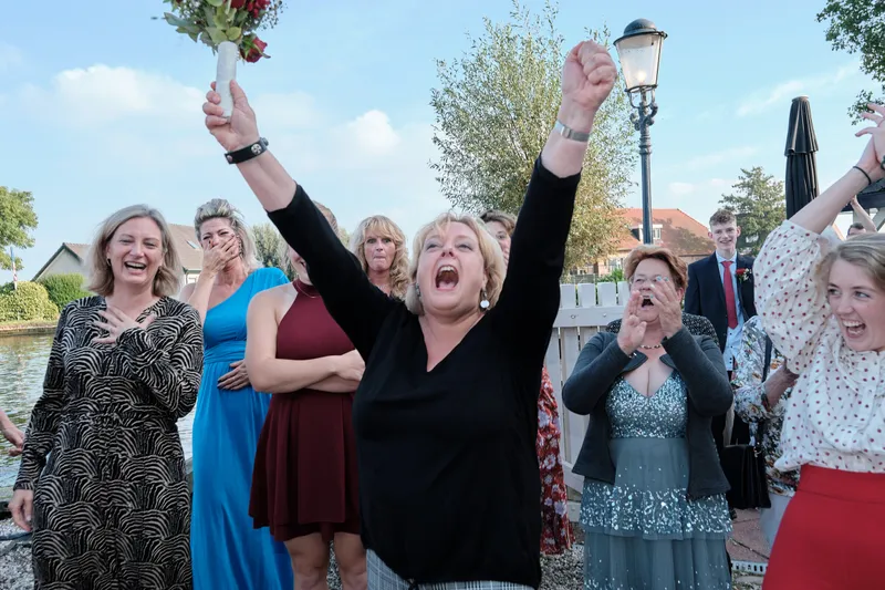 Gasten juichen met hun armen in de lucht aan het water