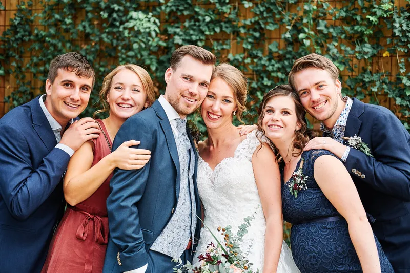 Kirsten en Jouke met vier vrienden voor een groene muur