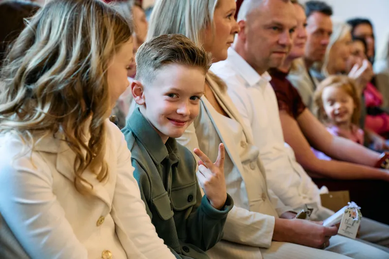 Een jongen lacht tussen de gasten