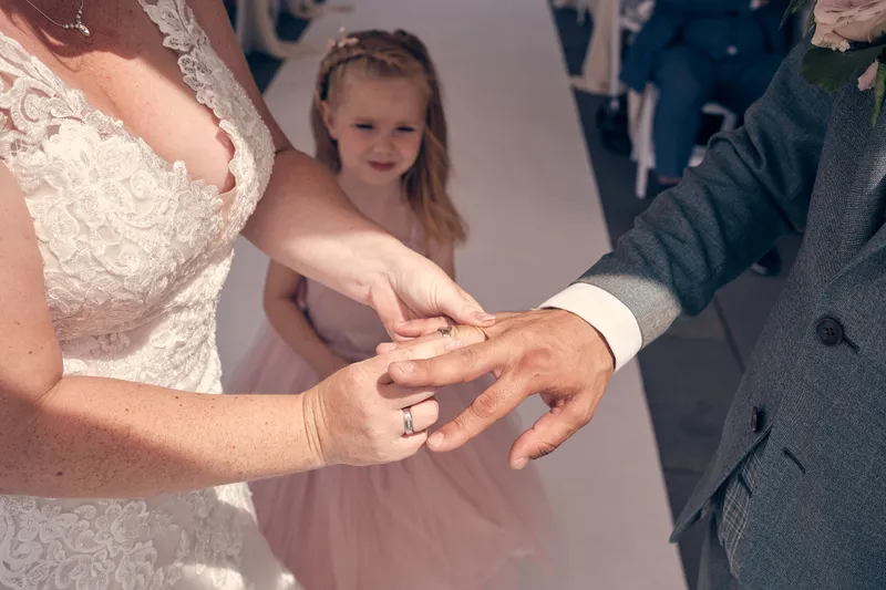 Hun dochter kijkt toe terwijl de ringen worden gewisseld