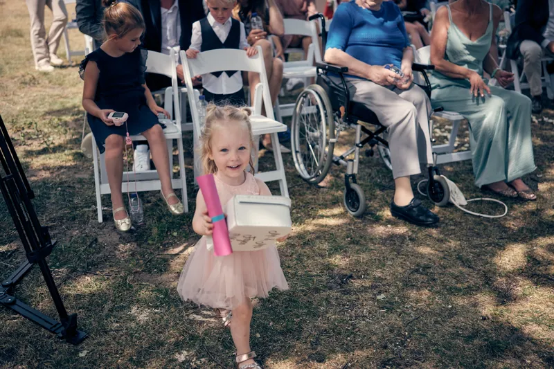 Een van de dochtertjes loopt tussen de stoelen naar voren