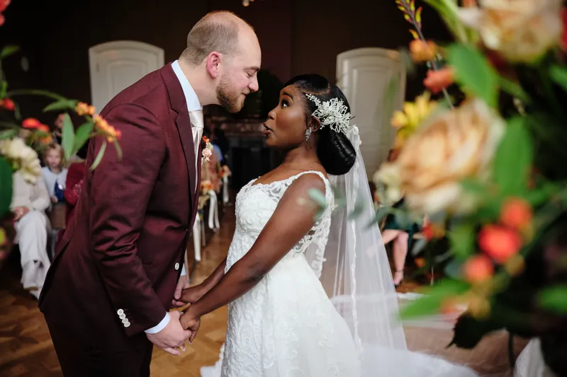 Natascha en Tim kussen elkaar, met herfstbloemen op de voorgrond