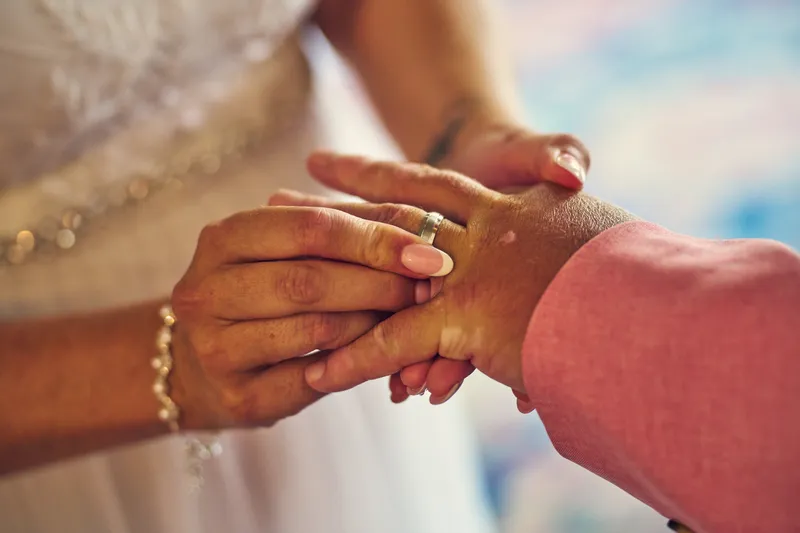 Een trouwring wordt om een vinger geschoven