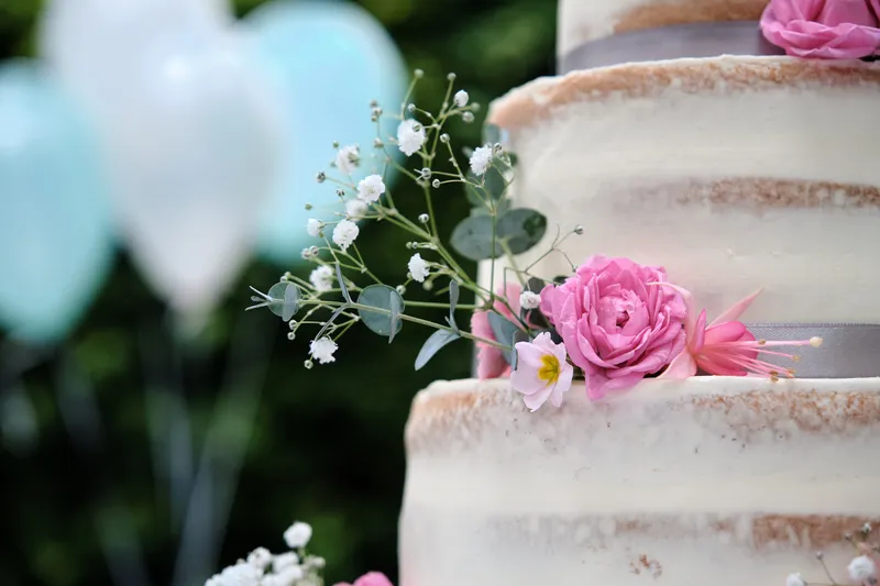 De naked cake met roze bloemen