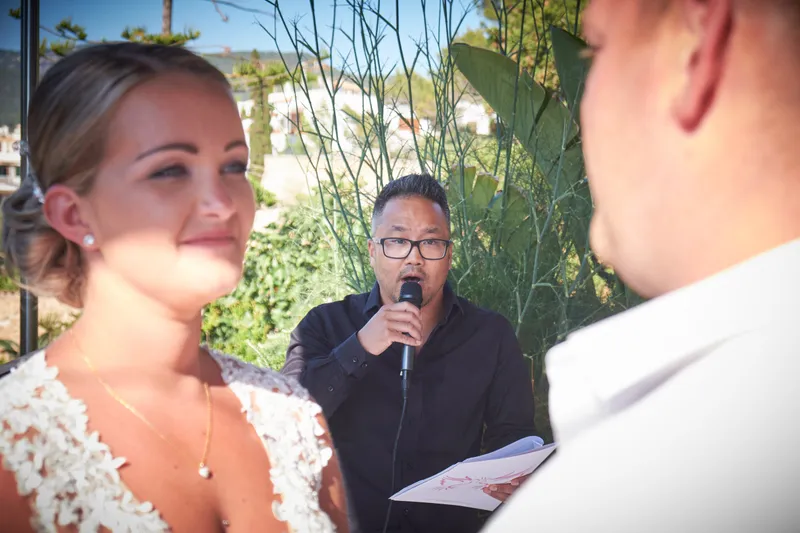 De trouwambtenaar spreekt met de microfoon, Stephanie luistert