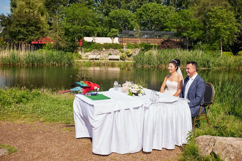 De ceremonietafel aan het water, met het groen van het vogelpark eromheen