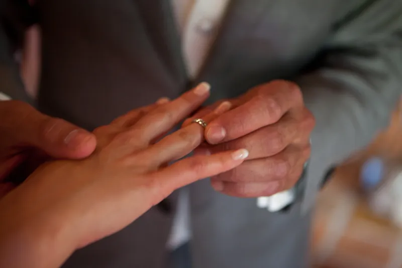 Dennis schuift de ring om de vinger van Rebecca