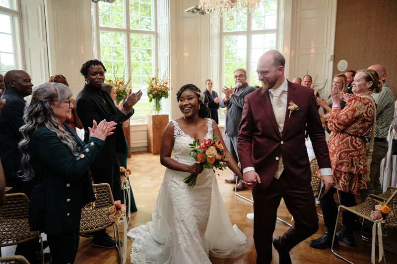 Natascha en Tim lopen als getrouwd stel de salon uit, de gasten klappen