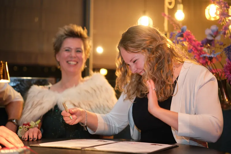 Esther lacht met een getuige bij het tekenen