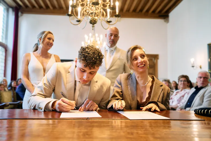 Hun zoon zet zijn handtekening onder de kinderakte, Danitsja en Brian kijken mee