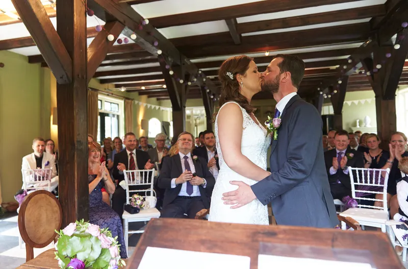 Robbert en Nadine kussen voor de gasten in de zaal