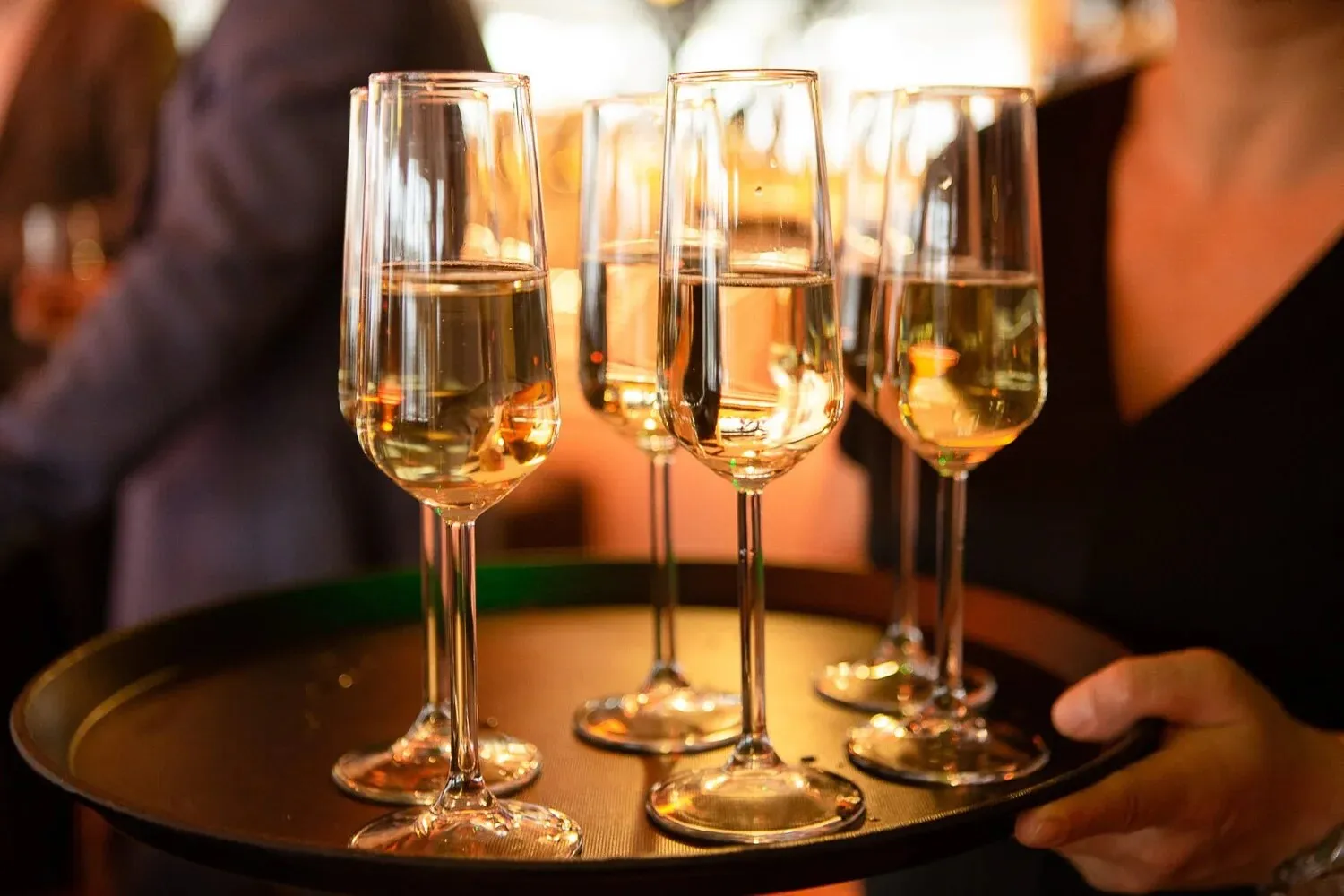 Een dienblad met glazen champagne in warm licht