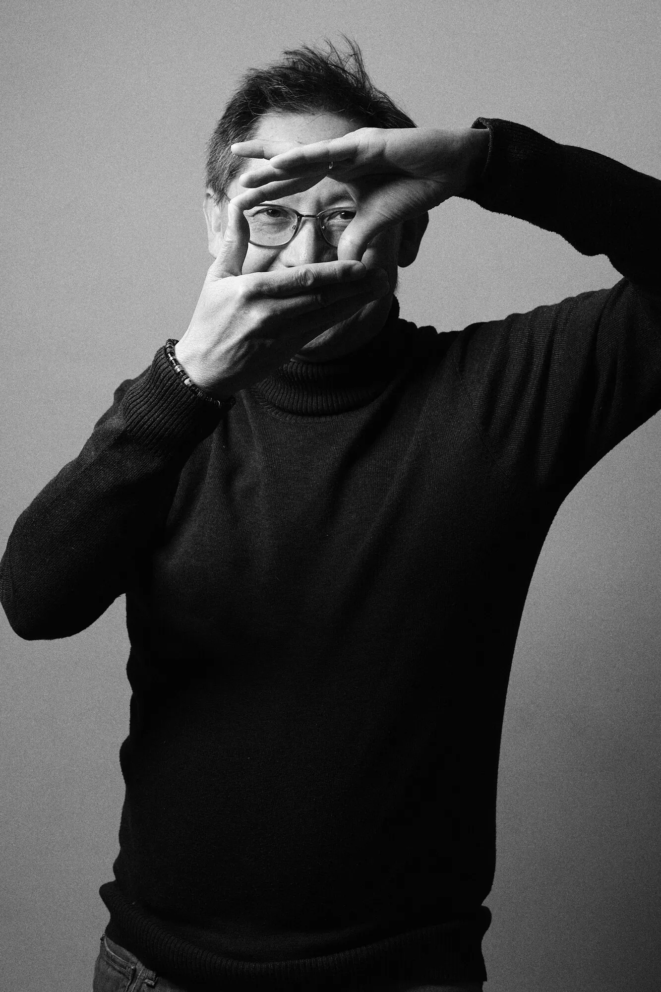 Zwart-witportret van Chris Lans die met zijn handen een kader vormt voor zijn oog