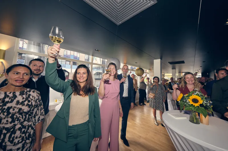 Een gast heft haar glas voor de toast