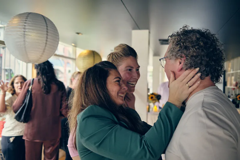 Gerrit wordt gefeliciteerd door een gast in een groen pak
