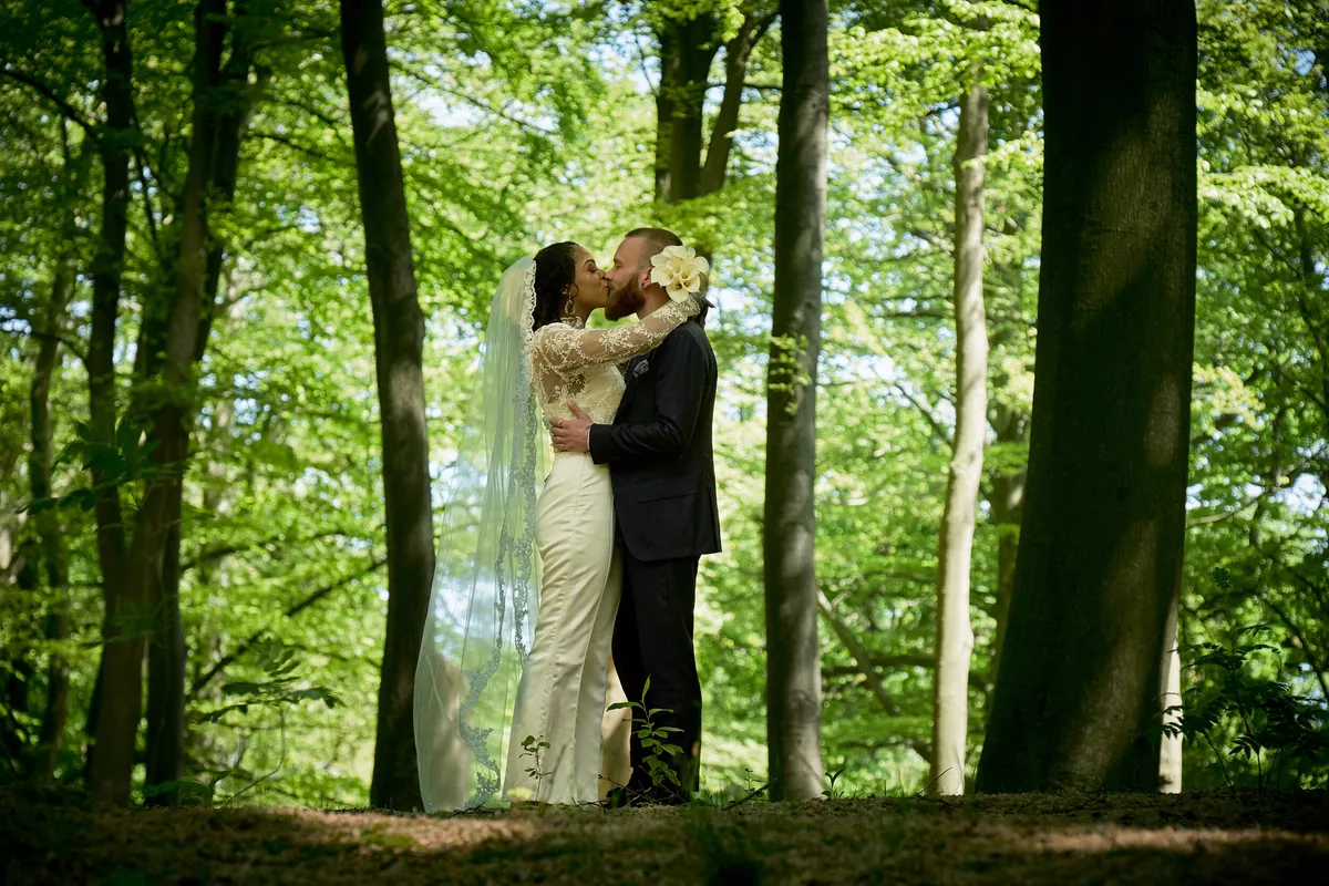 Frank en Jennifer kussen tussen de hoge beuken van Clingendael