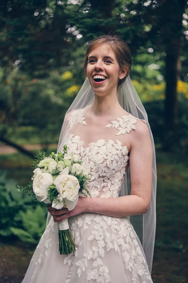 Marjolijn lacht met haar witte boeket