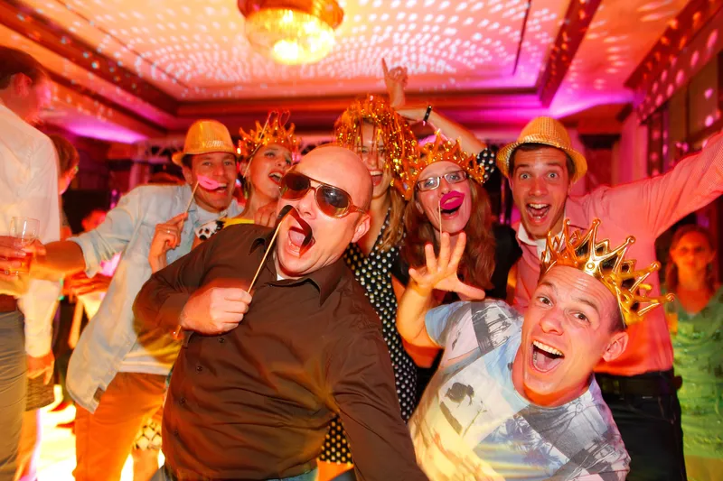 Gasten met hoeden en gekke brillen op de dansvloer