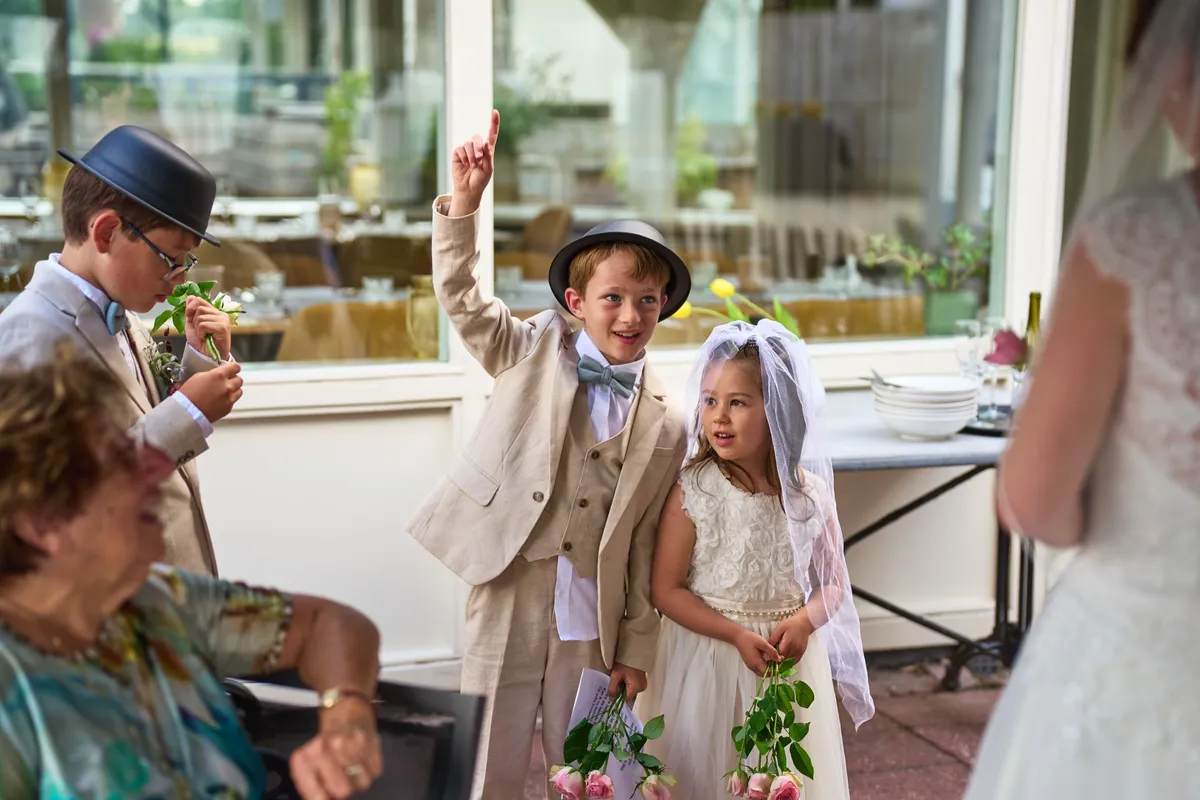 De kinderen met hoedjes en een sluier maken plezier bij het diner