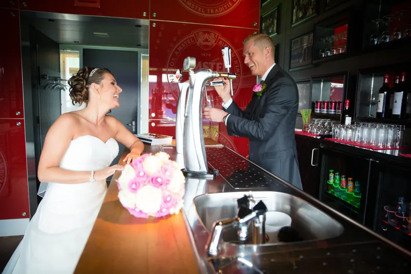 Michelle tapt een biertje achter de bar in De Kuip, Sven kijkt toe
